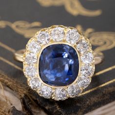 This Victorian component lived its' first life as the centerpiece to a fabulous antique bangle which didn't see much daylight, as one doesn't tend to wear big diamond cluster bangles everyday! We felt she was too beautiful to be couped up as such, so we added a simple gold shank to that center and this beautiful sapphire and old mine cut diamond cluster ring was born!The center has been designated by the UK's Gemological Certification Services as a Ceylon, no-heat sapphire with an estimated weig Cushion Cut Rose Cut Diamond Jewelry, Victorian Gemstone Cluster Ring For Wedding, Victorian Gemstone Cluster Wedding Ring, Exquisite Sapphire Diamond Ring With 17 Jewels, Classic Cluster Sapphire Jewelry, Vintage Sapphire Cluster Ring With Gemstones, Classic Sapphire Cluster Jewelry, Heirloom Sapphire Jewelry With Single-cut Diamonds, Heirloom Sapphire Jewelry With Single Cut Diamonds