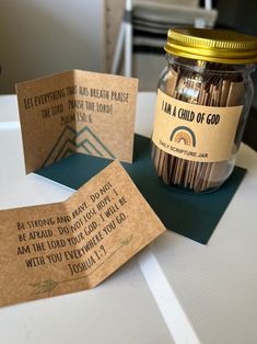 some brown paper tags sitting on top of a table next to a jar of matches