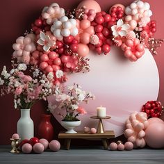 balloons and flowers are arranged around a large heart shaped balloon backdrop on a pink wall