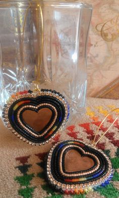 two heart shaped beaded earrings sitting on top of a rug