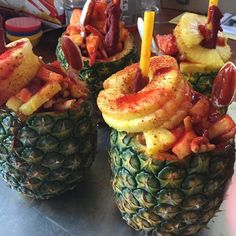 three pineapples with bacon and shrimp on them