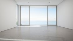 an empty room with large windows overlooking the ocean