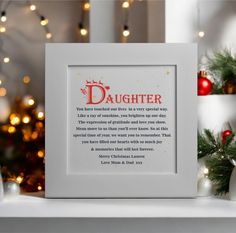 a white frame with the words daughter on it in front of christmas decorations and lights