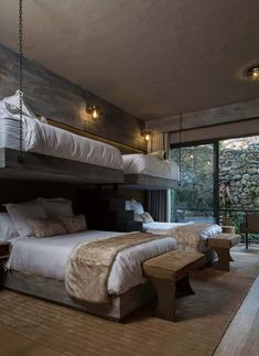 a bedroom with two bunk beds and a bench in front of the bed is made from wood