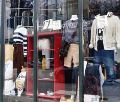 a window display with clothing and luggage in it