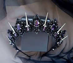 a black tiara with purple stones on it