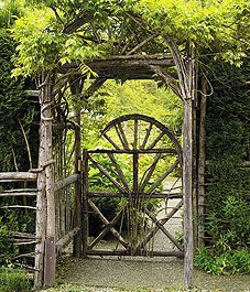 an old wooden gate surrounded by greenery