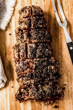 a wooden cutting board topped with sliced up brownies next to a knife and fork