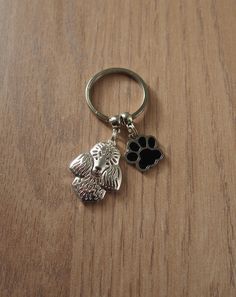 a key chain with a dog's paw on it and a cat's head in the middle