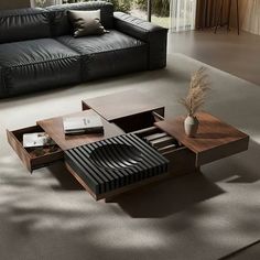 a modern living room with black leather couches and coffee table in front of large windows