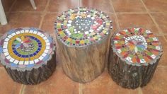 three wooden stumps sitting on top of a floor covered in colorful glass tile tiles