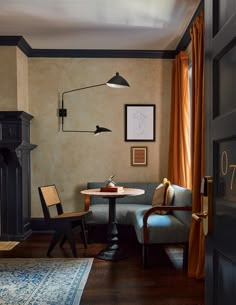 a living room filled with furniture and a fire place next to a table on top of a hard wood floor