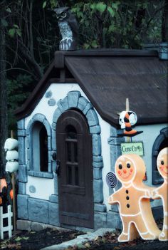 a house made to look like gingerbreads with a cat sitting on the roof