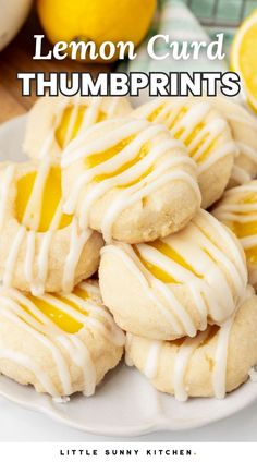 lemon curd thumbprints with white icing on a plate next to sliced lemons