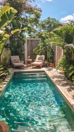 an outdoor pool surrounded by greenery and chairs in the middle of a backyard area