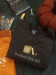 some books are laying on the floor next to a t - shirt