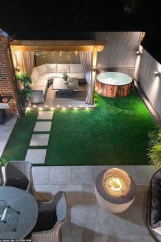 an outdoor living area is lit up at night with lights on the patio and fire pit