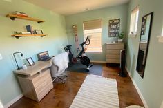 a room with a desk, chair and other items on the floor in it's corner