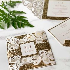 wedding stationery with gold glitter and monogrammed envelopes on a marble table