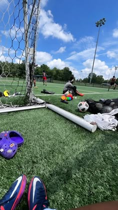 the soccer goalie's shoes are laying on the grass next to the net