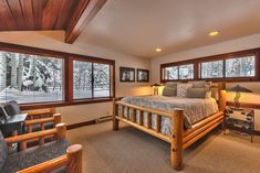 a bedroom with a large bed and two windows