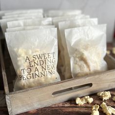 several bags of popcorn sitting on top of a wooden box next to some kernels