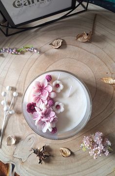 there is a cake with flowers on the table next to some leaves and spoons