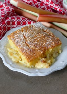 a piece of cake on a white plate next to some apples and other food items