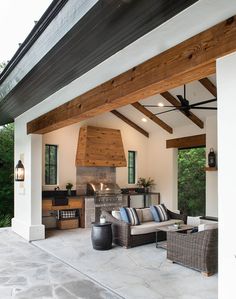 an outdoor living area with couches and fireplace