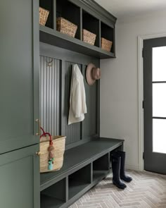 a coat rack with two coats hanging on it and some boots in the foreground