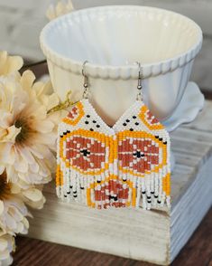 "These boho earrings feature a design with pink grapefruit slices over a white background. I like to think of them as part of a mini collection that came into being while I was dreaming of beaches and bottomless pitchers of sangria. Check out my other fruity beaded curtain pieces to see the full collection! The hand stitched beadwork is carefully woven with white nylon. Nylon holds up well to moisture, however it is strongly recommended to remove them before swimming, showering, and sleeping. The earring hook is silver plated base metal. The entire earring from hook to bottom is 3 5/8\", but the actual beadwork is 2 3/4\" in total. These fringe earrings ship for free in the US. If you are gifting them to someone else, send me a note and I will include your personalized gift message!" Beaded Fruit Earrings, Grapefruit Slice, Seed Bead Fringe Earrings, Bead Fringe Earrings, Beaded Curtain, Bead Fringe, Mini Collection, Fruit Earrings, Earrings Summer