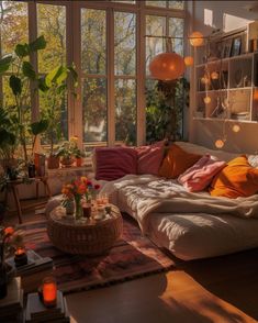 a living room filled with lots of furniture and windows covered in plants, candles and lights