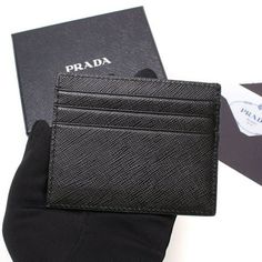 This stylish Prada Card Holder is the perfect addition to your everyday essentials. The iconic Prada Embossed logo is featured prominently on the front. With six slots for cards as well as one down the middle, there is plenty of storage for all of your needs. Its small size and neutral color makes this leather card holder perfect to place in your pocket or bag. Made in Italy. Model: 2MC223 Black and Grey Saffiano Leather Prada Silver Logo Six card holder slots One bill compartment Measurements: Classic Business Card Holder With Logo, Designer Business Card Holder With Logo, Designer Logo Card Holder For Business, Classic Black Card Holder With Logo, Designer Rfid Blocking Card Holder Gift, Designer Bifold Card Holder For Business, Designer Bifold Business Card Holder, Elegant Rectangular Logo Card Holder, Classic Business Wallet With Logo