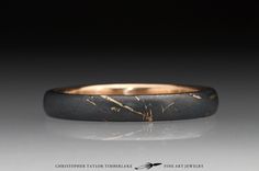 a black and gold wedding ring on a gray background