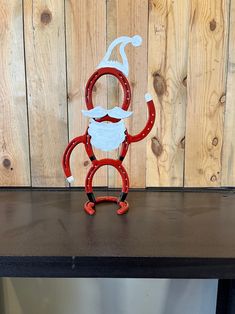 a red and white metal monkey with a beard and mustache on it's head