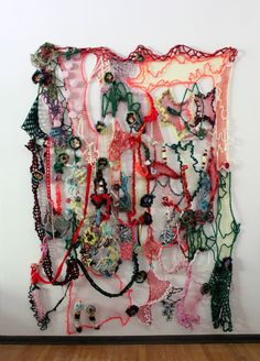 there is a wall hanging made out of many different pieces of clothing and jewelry on it