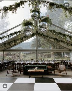 the inside of a tent with tables and chairs set up for an outdoor party or function