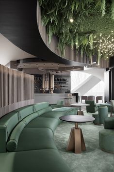 the interior of a modern restaurant with green couches