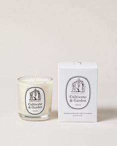 a candle sitting next to a box on a white surface with the label cut out