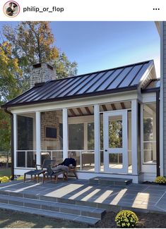 a person sitting on a chair in front of a porch with glass doors and windows