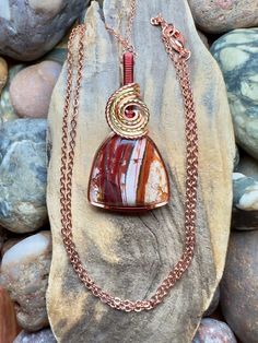 "Royal flamingo jasper/Howardite with copper, gold, and burgundy wire wrap Comes with 18\" sterling silver plated chain shown in photos.  Pendant measures 1-5/8\" x 7/8\"" Wire Wrapped Ocean Jasper Pendant Necklaces, Ocean Jasper Wire Wrapped Pendant Necklaces, Wire Wrapped Ocean Jasper Pendant Necklace, Wire Wrapped Jasper Pendant Necklace, Hand-wrapped Jasper Pendant Necklace, Hand Wrapped Jasper Pendant Necklace, Spiritual Jasper Necklaces Wire Wrapped, Spiritual Jasper Necklaces With Wire Wrapped, Wire Wrapped Jasper Necklaces As Gifts