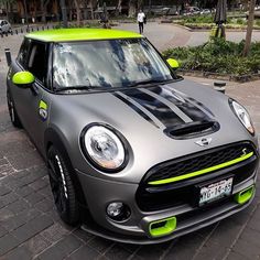 a grey mini with neon green trim parked on the street