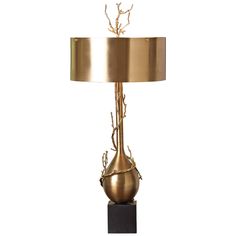 a lamp that is sitting on top of a wooden block with a metal base and a gold shade