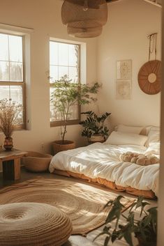 a bed sitting in a bedroom next to two windows with plants on the floor and potted plants