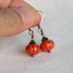 Celebrate the season with these small and cute pumpkin earrings, perfect for fall, Thanksgiving, or any autumn occasion. Made with Czech glass pumpkin beads (8x11 mm), accented by tiny green glass beads and small metal bead caps, they are completed with warm solid copper earring wires. These charming earrings capture the spirit of the harvest and add a festive touch to your outfit. Thanksgiving Earrings, Pumpkin Beads, Autumn Earrings, Pumpkin Bead, Earrings Fall, Metal Bead, Small Pumpkins, Pumpkin Earrings, Earring Wires