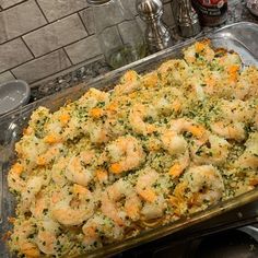 a casserole dish with shrimp and cheese in it sitting on a counter top