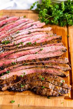 steak sliced up on a cutting board with parsley