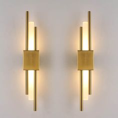 two lights that are next to each other on a white wall, one is gold and the other is silver