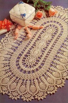 an old doily with roses on it next to a candle and some other items