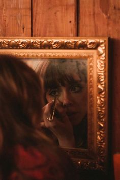 a woman is looking at her reflection in the mirror